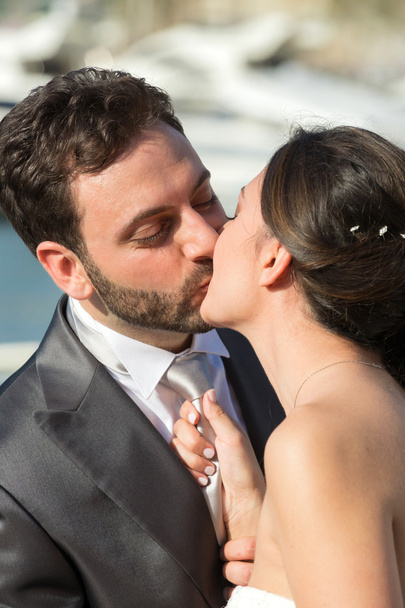 Bride pulls the tie of the groom while kissing him. - Photo, Image
