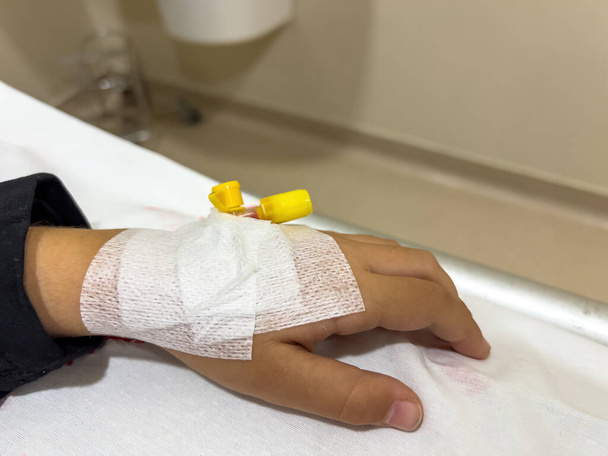 Αγγειακή πρόσβαση στο χέρι του νεαρού άρρωστου κοριτσιού στο κρεβάτι του νοσοκομείου - Φωτογραφία, εικόνα
