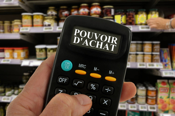 Concetto di potere d'acquisto con una calcolatrice in mano e scaffale sfocato del supermercato sullo sfondo - Foto, immagini