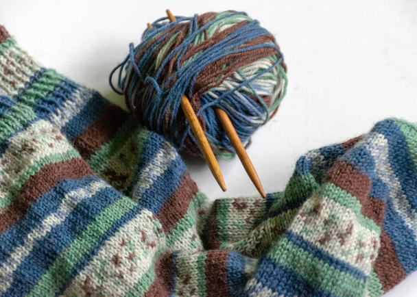 Woolen knitted socks, knitting yarn and knitting needles, knitted fashion, needlework clothing, winter hobby, needlework concept. Homemade crochet, needlework - Photo, Image