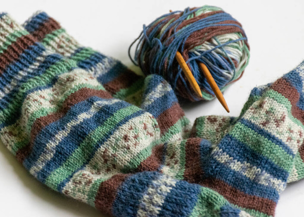 Woolen knitted socks, knitting yarn and knitting needles, knitted fashion, needlework clothing, winter hobby, needlework concept. Homemade crochet, needlework - Photo, Image