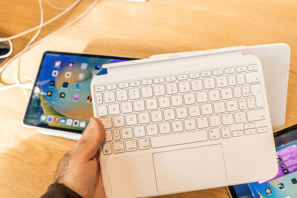 Paris, Frankreich - 28. Oktober 2022: Mann benutzt neue Apple-Computer-Tastatur mit Touchpad - Foto, Bild