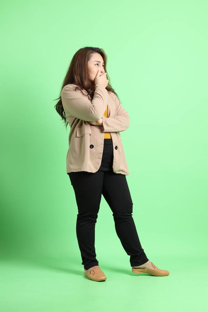 The adult Asian business woman standing on the green background. - Foto, immagini