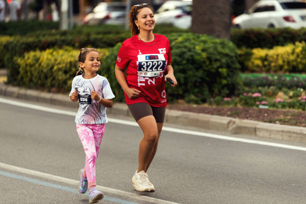 Izmir, Turkey - September 11, 2022: One woman and a girl competitors running in the half marathon are running special for the 100th anniversary of Izmir's liberation. - Foto, Bild