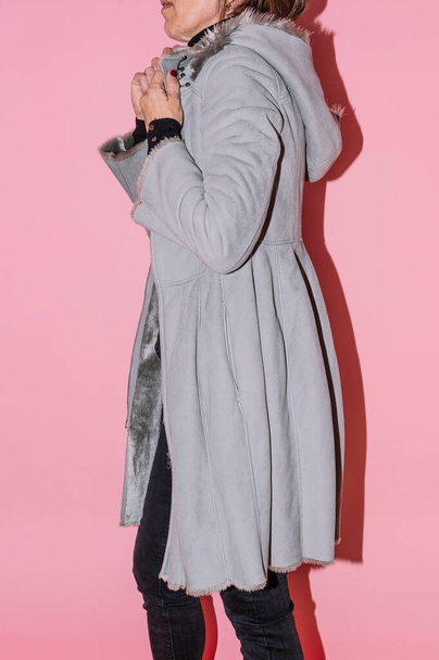 Vrouw die het jasje laat zien dat ze tweedehands wil verkopen op een tweedehands kledingwebsite. - Foto, afbeelding