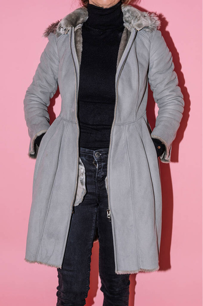 Vrouw die het jasje laat zien dat ze tweedehands wil verkopen op een tweedehands kledingwebsite. - Foto, afbeelding
