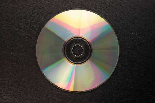 One CD-R disc on slate stone, macro, top view. - Photo, Image