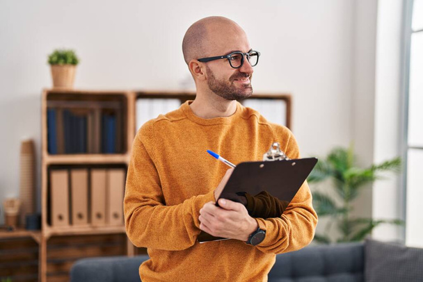 Young man business worker smiling confident holding clipboard at office - Photo, Image