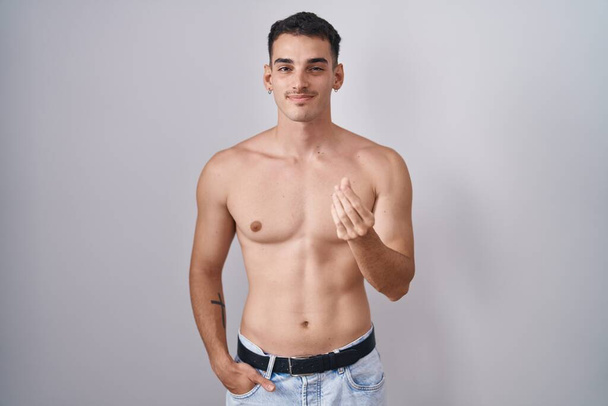 Handsome hispanic man standing shirtless doing money gesture with hands, asking for salary payment, millionaire business  - Foto, imagen