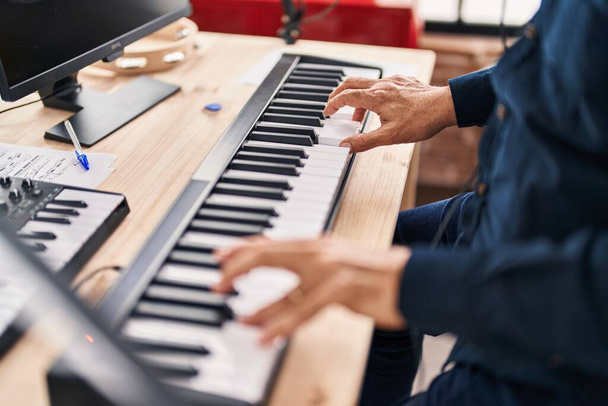 Старший музикант грає на клавіатурі фортепіано в музичній студії
 - Фото, зображення