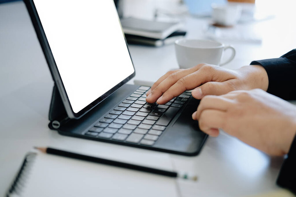 El hombre joven que usa el trabajo de la tableta casera en el trabajo, el espacio en blanco en la pantalla de la computadora puede insertar texto - Foto, Imagen