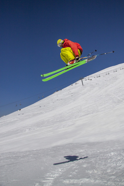 Skier saute contre le ciel bleu dans une journée ensoleillée
. - Photo, image