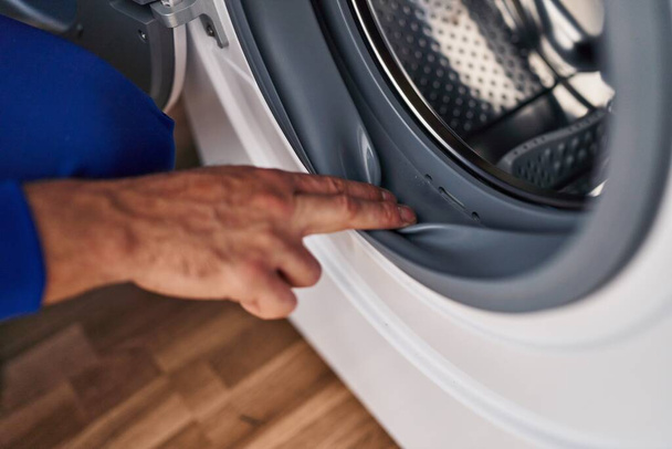 Jovem hispânico técnico limpeza máquina de lavar roupa na lavanderia - Foto, Imagem