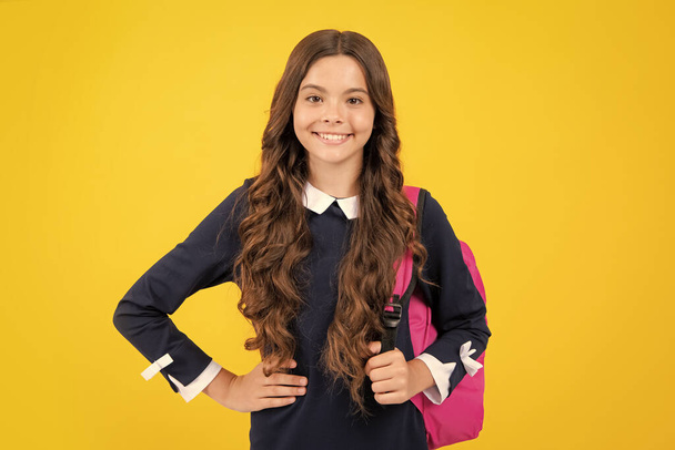 School teen girl in with backpack. Teenager student on yellow isolated background. Learning, education and knowledge - Foto, Imagem