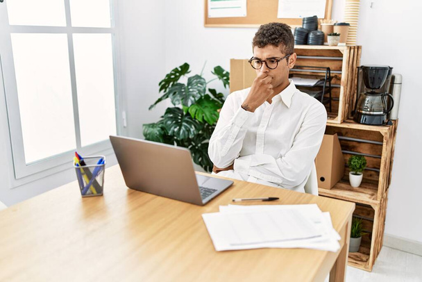 Jovem hispânico pensando em trabalhar com laptop no escritório de negócios - Foto, Imagem