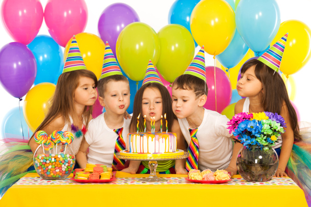 Enfants célébrant fête d'anniversaire et soufflant des bougies sur le gâteau
 - Photo, image