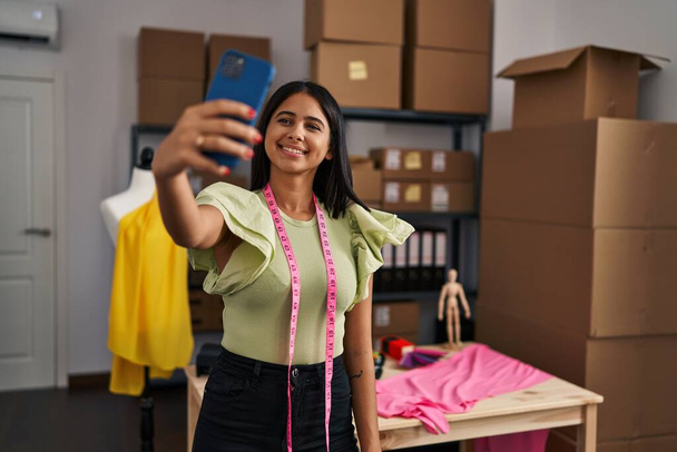 Trabajador de negocios de comercio electrónico joven mujer latina hacer selfie por el teléfono inteligente en el estudio de diseño - Foto, imagen