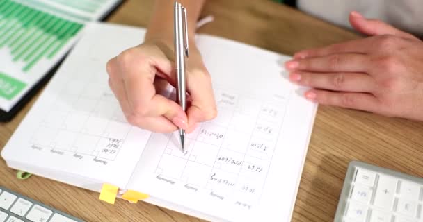 Vrouw schrijft notities, to-do lijst en dagboek voor budget planning en vergaderingen. Studentenhanden huiswerk en onderzoek leren - Video