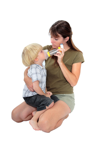 Joven madre dando medicina respiratoria a su hijo
 - Foto, Imagen