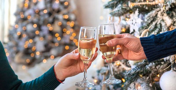 Man and woman with champagne in their hands near the Christmas tree. Selective focus. Couple. - Foto, Imagen