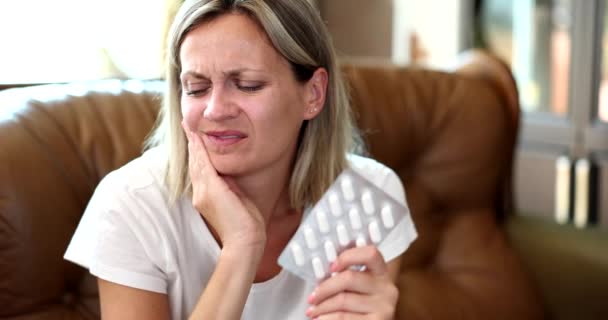 Portret biednej kobiety dotykającej policzka, odczuwającej dyskomfort i ból w okolicy zęba. Leki przeciwbólowe na ból zęba - Materiał filmowy, wideo