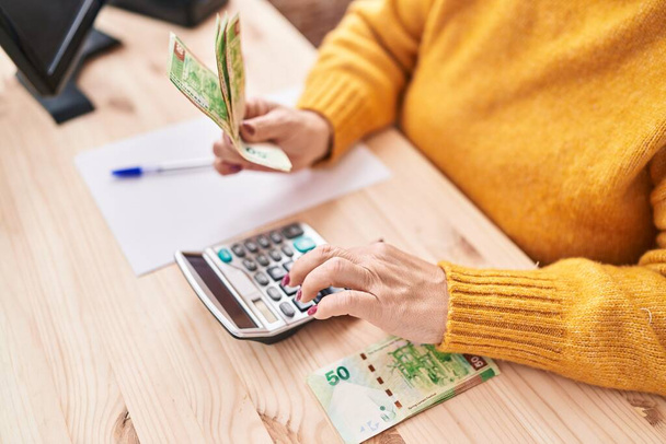 Середнього віку блондинка електронної комерції бізнес-працівник рахуючи hong Kong доларів в офісі
 - Фото, зображення