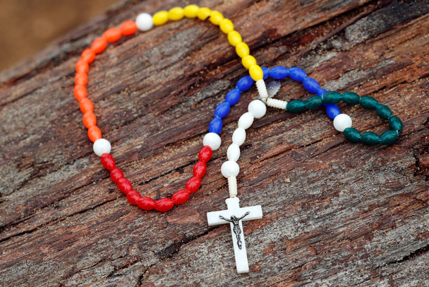 Colorful rosary on a trunk. - Photo, image