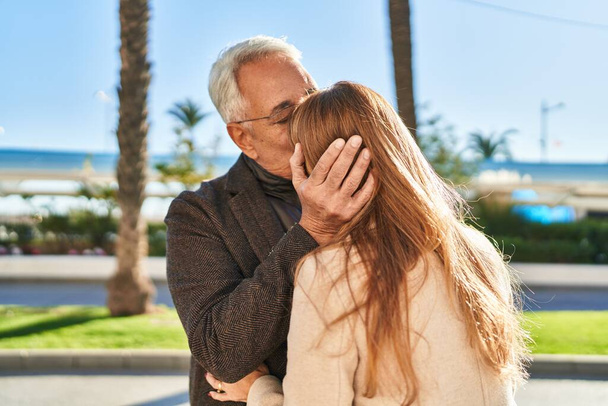 Orta yaşlı erkek ve kadın çift parkta birbirlerine sarılıyorlar. - Fotoğraf, Görsel