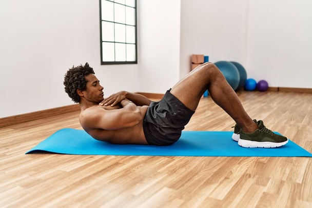 Young african american man training abs exercise at gym - Foto, immagini