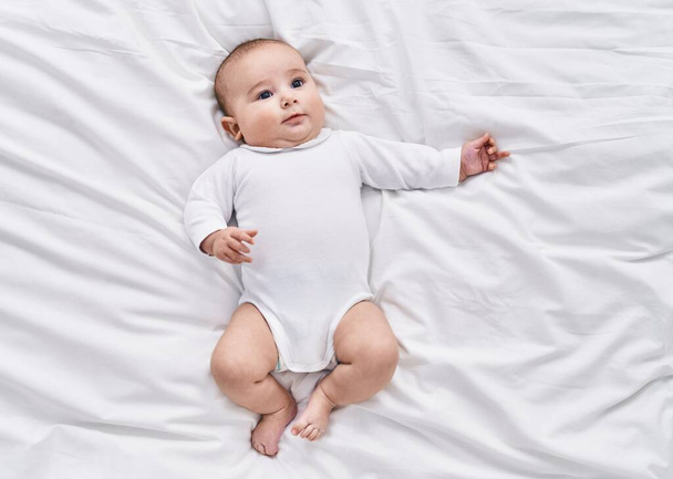 Adorable baby relaxed lying on bed at bedroom - Foto, Imagen