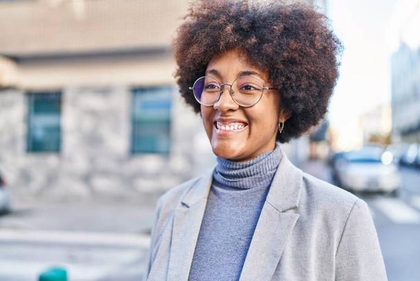 Afrikaans amerikaanse vrouw executive glimlachen zelfverzekerd staan op straat - Foto, afbeelding