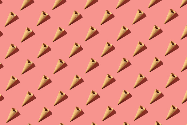 a hard light pattern of an empty waffle ice cream cone on bright colorful pink background, flat lay, top view - Valokuva, kuva