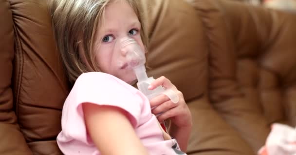 Ragazzina con maschera inalatrice a casa. Bambino malato respira attraverso il nebulizzatore - Filmati, video