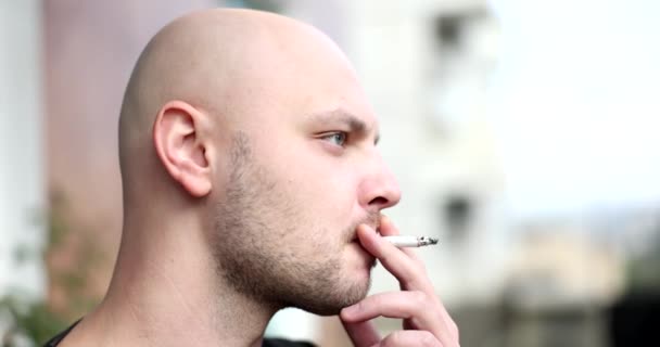 Il giovane fuma sigarette o tabacco. Guy è dipendente dalle sigarette e fuma sempre un sacco di sigarette ogni giorno - Filmati, video