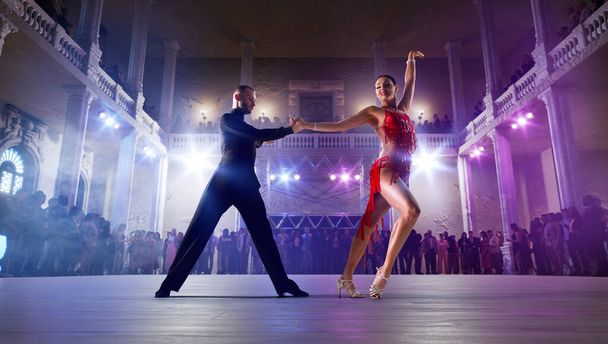 Para tancerzy wykonuje taniec latynoski na dużej scenie zawodowej.  - Zdjęcie, obraz
