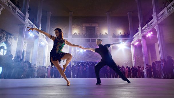 二人のダンサーは大規模なプロの舞台でラテンダンスを行う.  - 写真・画像