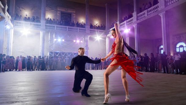 Ζευγάρι χορευτές εκτελούν λατινικό χορό σε μεγάλη επαγγελματική σκηνή.  - Φωτογραφία, εικόνα
