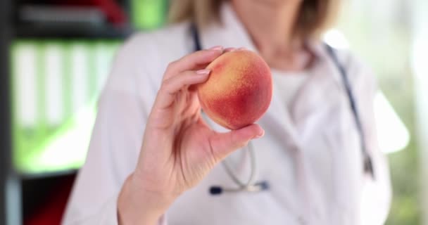 Γιατρός διατροφολόγος σας προσφέρει φρέσκα νόστιμα ροδάκινο. Υγιεινός τρόπος ζωής βιταμίνες και φρούτα - Πλάνα, βίντεο