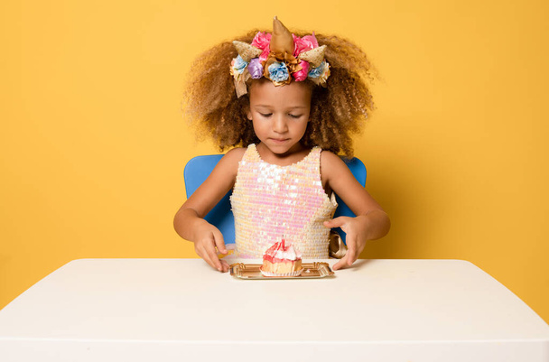 Sorridente bellezza bambino ragazza con torta di compleanno fatto cinque anni isolato su sfondo giallo - Foto, immagini