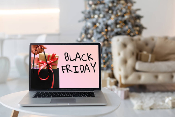 Black Friday concepto de compras escrito en la pantalla negra de los ordenadores portátiles contra el fondo borroso luces de Navidad. - Foto, imagen