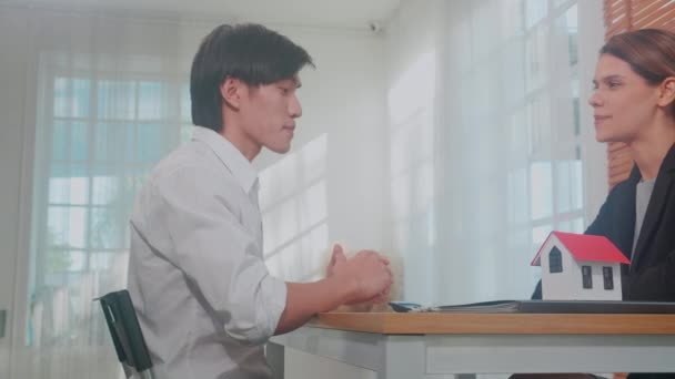 Mladý asijský muž zákazník mluvit s agentem o smlouvě o koupi domu a souhlas hypotečních nemovitostí a vysvětlení pro plánování v domácí kanceláři, finance a investice, obchodní koncept. - Záběry, video