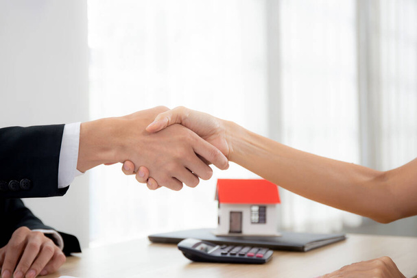 Closeup hands of real estate agent and customer handshake together after agreement together about credit house and insurance, client and consulting of investment about residential, business concept. - Photo, Image