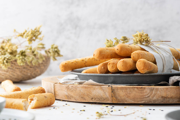 Breadsticks grissini. Bread sticks with sesame seeds, oregano and olive oil and balsamic vinegar on kitchen countertop. - Foto, imagen