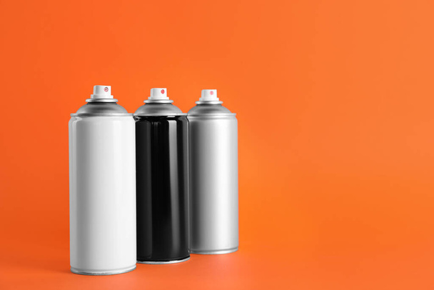 Cans of spray paints on orange background. Space for text - Valokuva, kuva