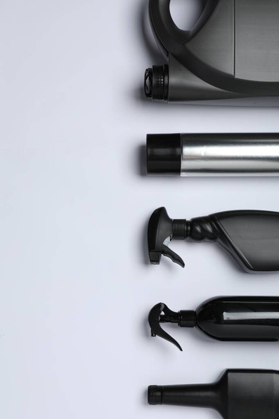 Black bottles and canister on white background, flat lay. Space for text - Foto, immagini