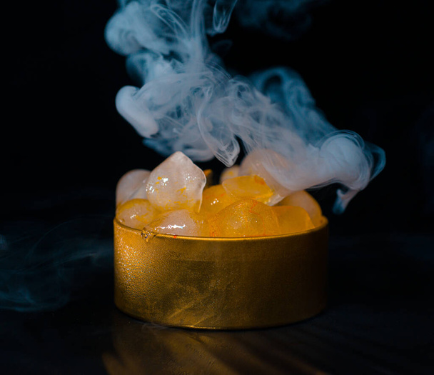 煙、カラフルな煙、青い煙、灰色の煙、シロップ、おいしい氷の氷と黄金のボックス内の氷。暗い背景の空間写真 - 写真・画像