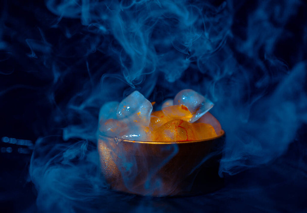 Ice in a golden box with smoke, colorful smoke, blue smoke, gray smoke, ice in syrup, delicious ice. space picture on dark background - Fotó, kép