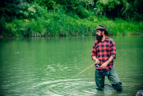 Fisherman man on river or lake with fishing rod - Foto, Imagem