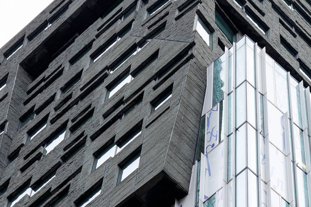  Moderní datová architektura. Detailní záběr budovy se skleněnou fasádou a černou texturovanou vložkou - Fotografie, Obrázek