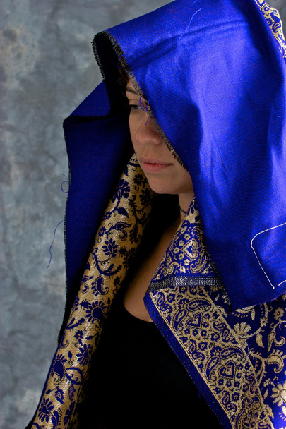 mystische Frau in blauem und goldenem Umhang mit Kapuze - Foto, Bild